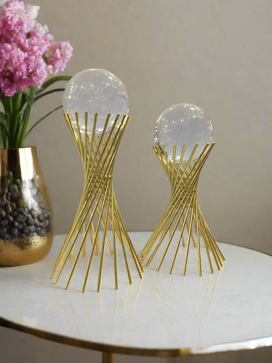 Two decorative items with gold and clear design on a store shelf.