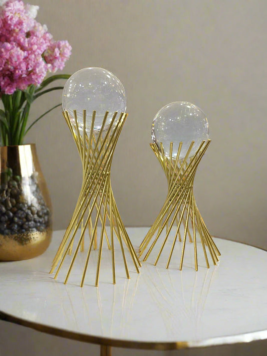 Two decorative items with gold and clear design on a store shelf.